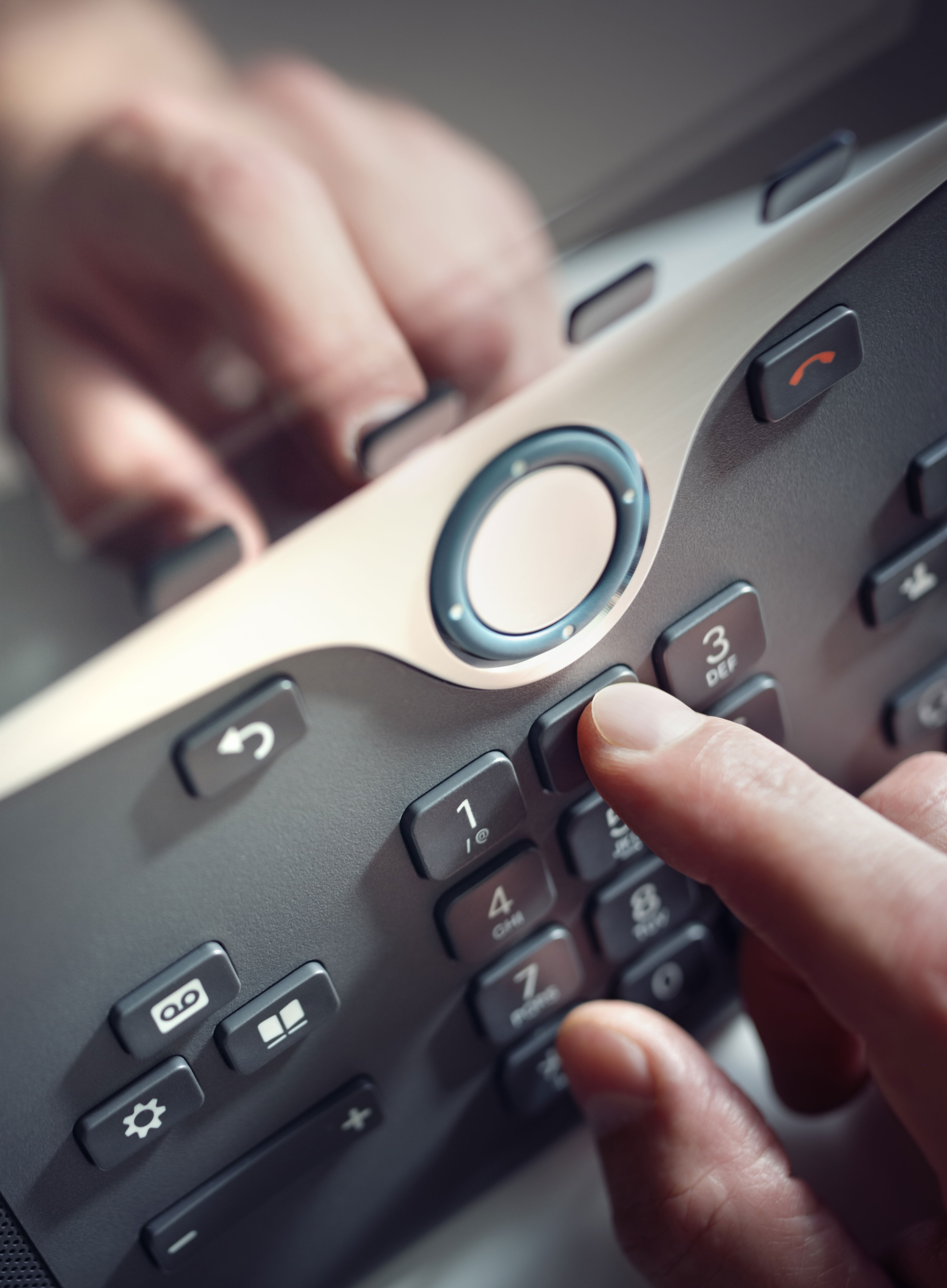 A finger pressing a telephone keypad